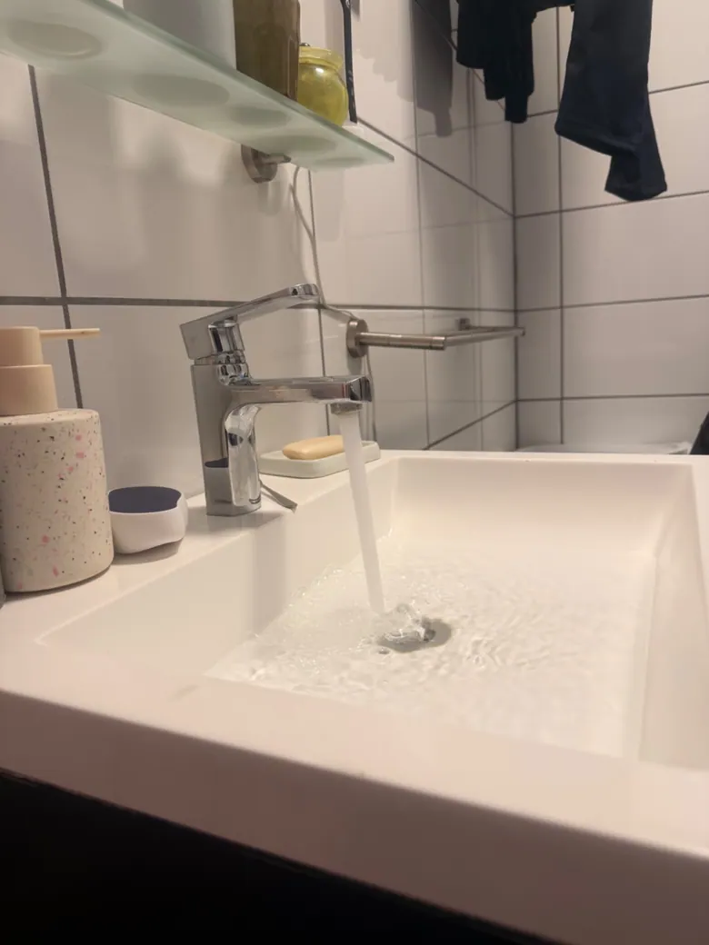 Monteur inspecteert een wastafelafvoer en sifon