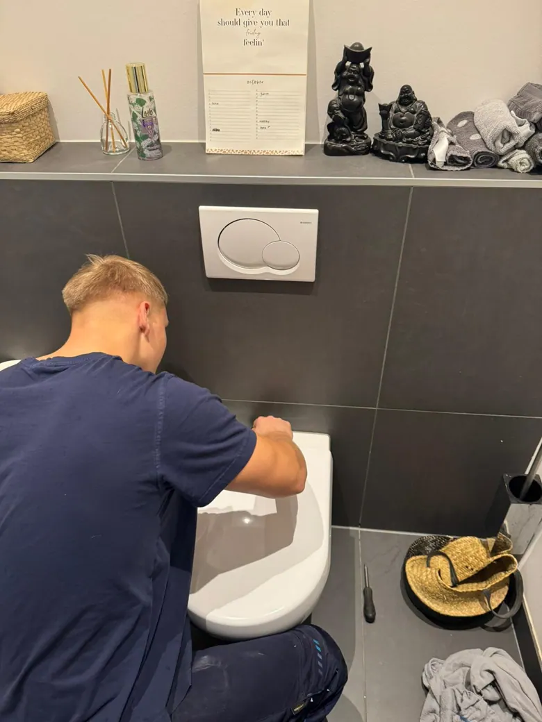 Monteur ontstopt een verstopte wc met professionele apparatuur